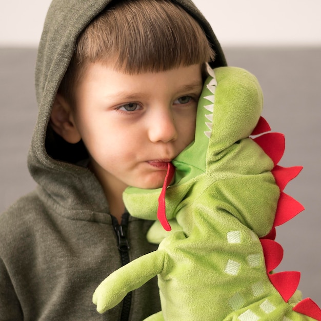 Boy in dinosaur costume with toy