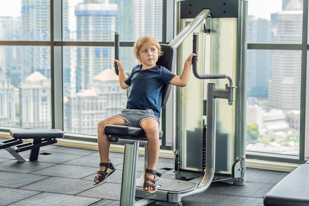 The boy does exercises in a fitness room