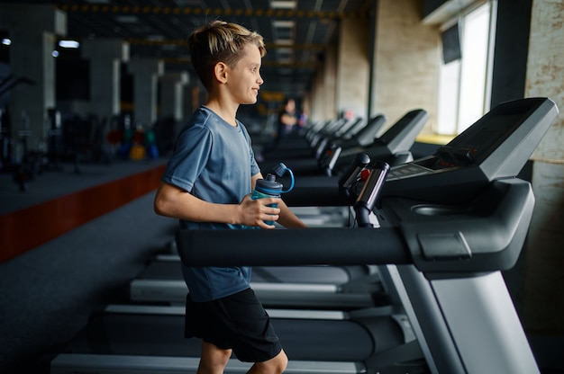 Boy doing exercise on treadmill in gym, running machine. Schoolboy on training, health care and healthy lifestyle