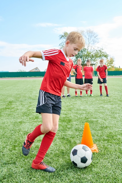 Photo boy doing football exercises