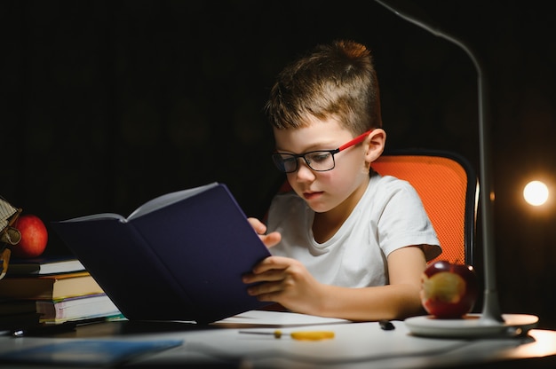 Boy doing homework at home in evening