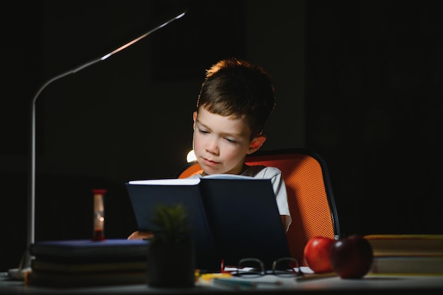 Photo boy doing homework at home in evening