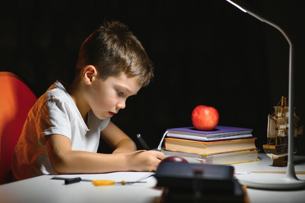 Photo boy doing homework at home in evening