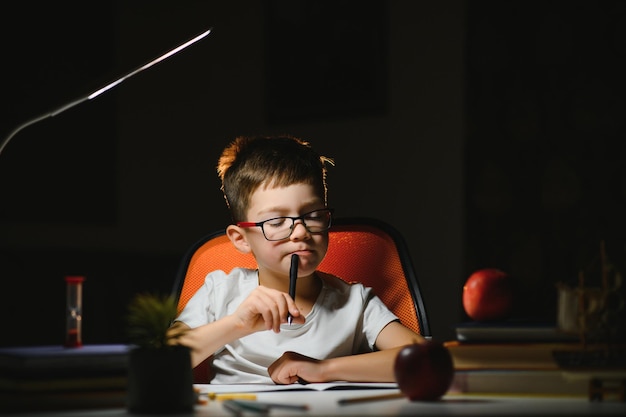 Boy doing homework at home in evening