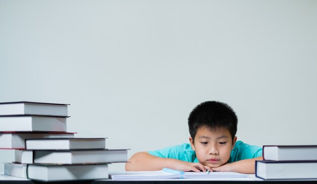 boy doing homework on white wall, education concept