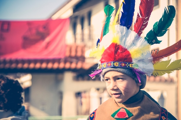 Boy dressed as a Native American Indian shows grimaces. - Image