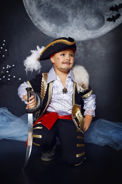 Boy dressed as a pirate against the backdrop of Halloween decorations