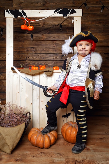 Boy dressed as a pirate against the backdrop of Halloween decorations