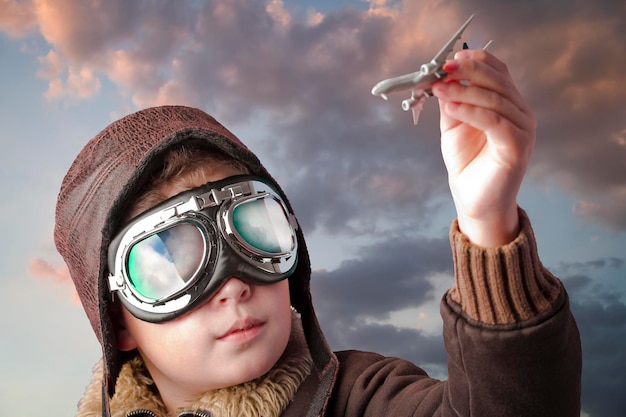 Boy dressed up in pilot´s outfit, jacket, hat and glasses.