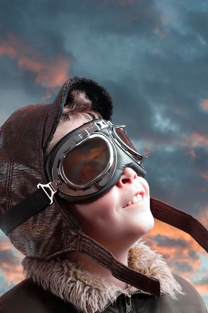 Boy dressed up in pilot´s outfit, jacket, hat and glasses.