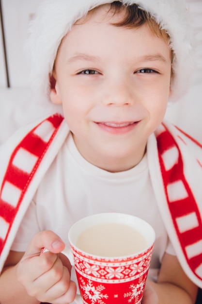 Boy drink cocoa in a mug