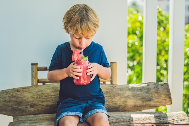 Boy drinking juicy watermelon smoothie