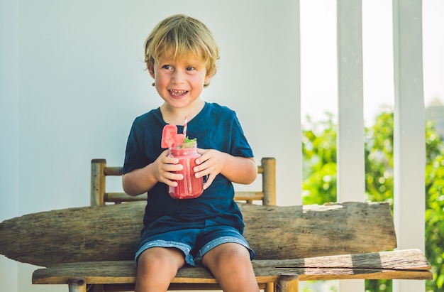 Boy drinking juicy watermelon smoothie