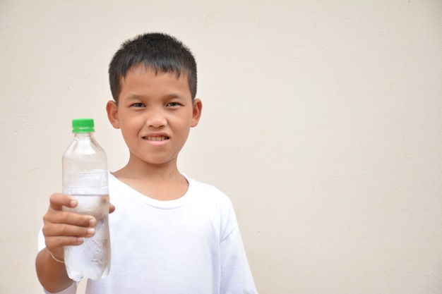 Boy drinking watercement gray background