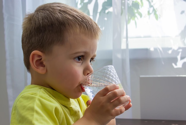 少年はグラスから水を飲む純粋な水夏