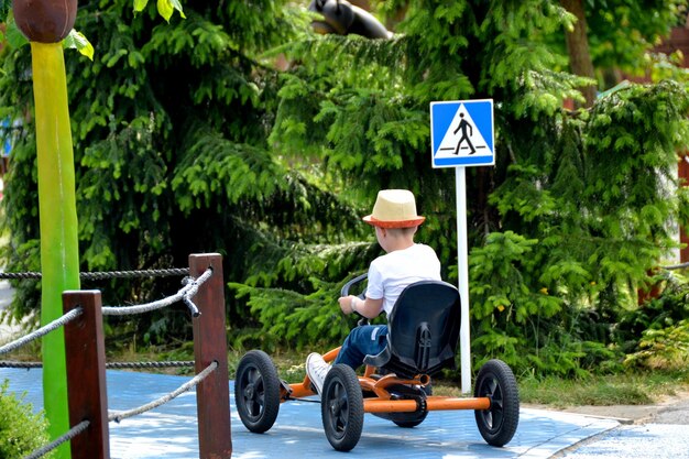 Foto ragazzo che guida quad bike a quattro ruote auto ciclo primavera brillantemente mattina giornata di sole