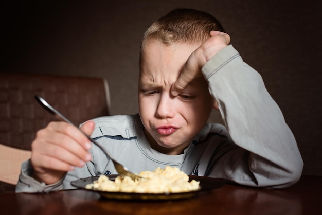 Foto un ragazzo che mangia una colazione con una forchetta.