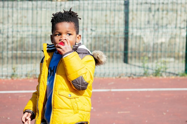 Photo boy eating food during sunny day