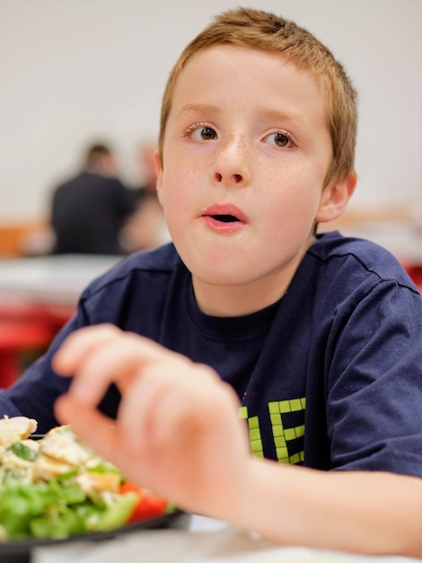 テーブルで食べ物を食べている少年