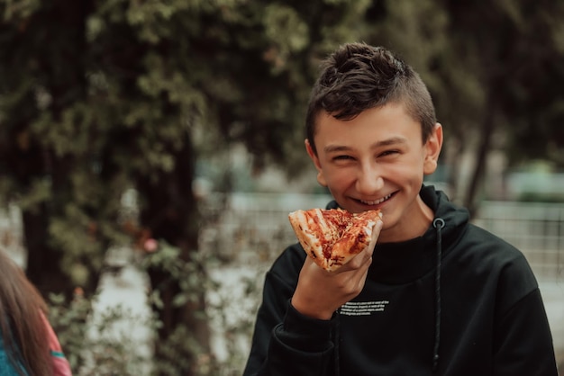 A boy eats pizza on a lunch break at school Selective focus High quality photo