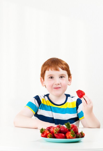 boy eats ripe strawberries