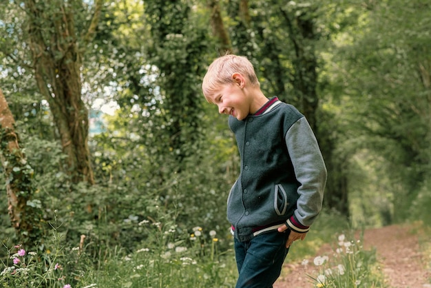 A boy of eight years old in a green forest in spring