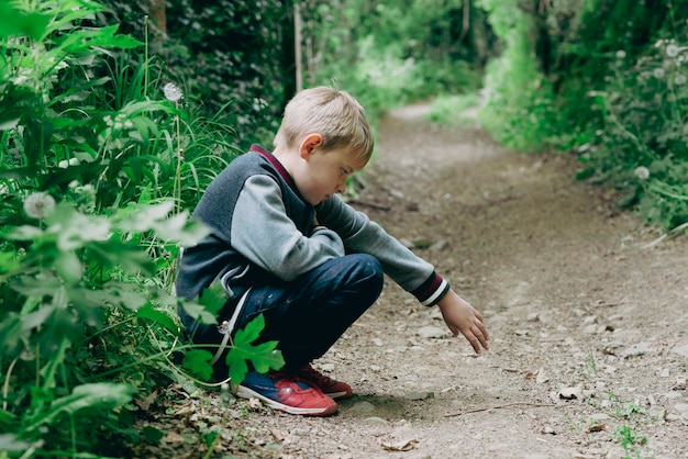 A boy of eight years old in a green forest in spring