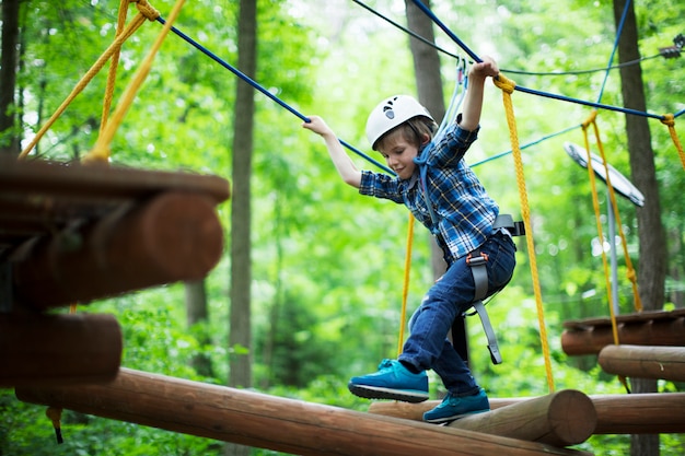 Boy enjoys climbing in the ropes course adventure