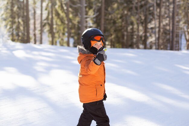 装備の少年が雪の斜面でスキーをしている