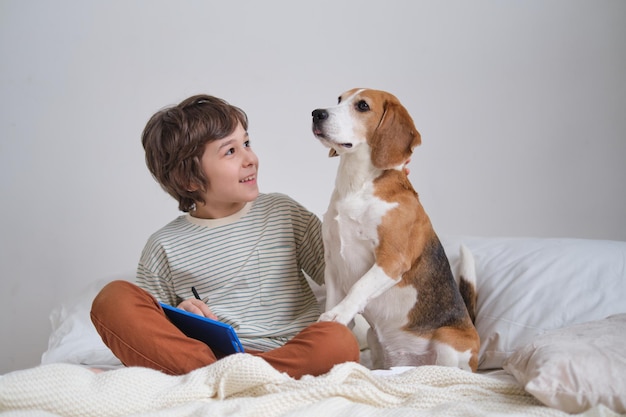 魅力的なスナップショットで愛情を込めて抱擁を共有する少年と忠実なビーグル犬 愛犬家が毛皮で覆われた仲間と抱き合い、幸せを発散している完璧な瞬間