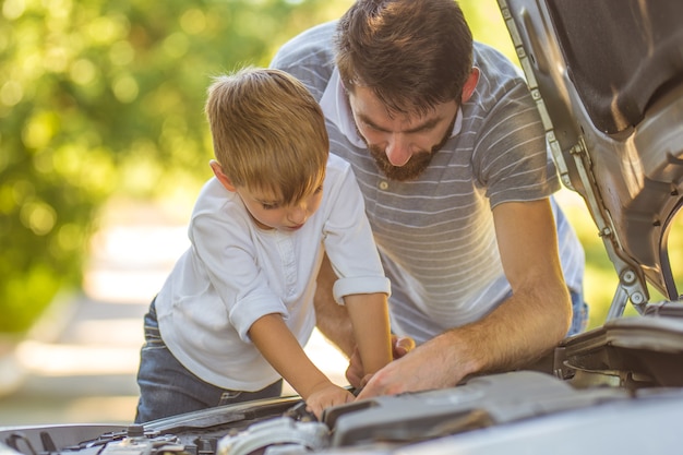 車を修理する少年と父親