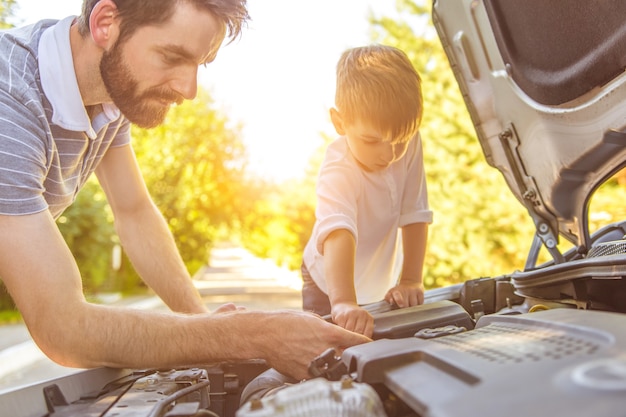 車を修理する少年と父親