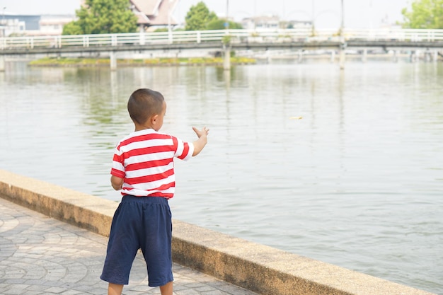 公園で魚に餌をやる少年