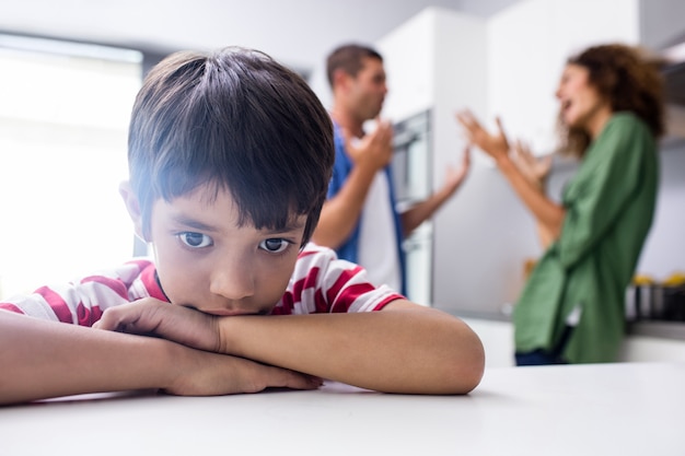 両親が口論している間、悲しい気持ちになっている少年