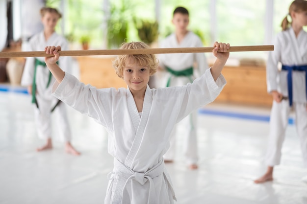 満足している少年。合気道を練習した後、興奮して満足しているかわいい黒い瞳の少年