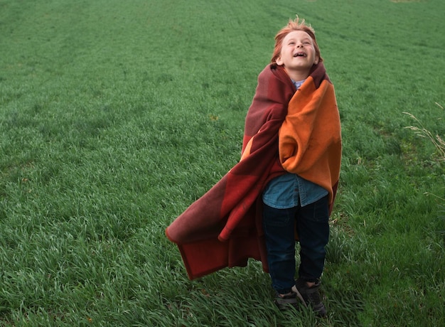 Мальчик в поле с одеялом