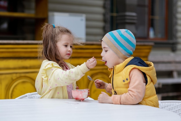 Photo a boy and girl are eating ice cream.