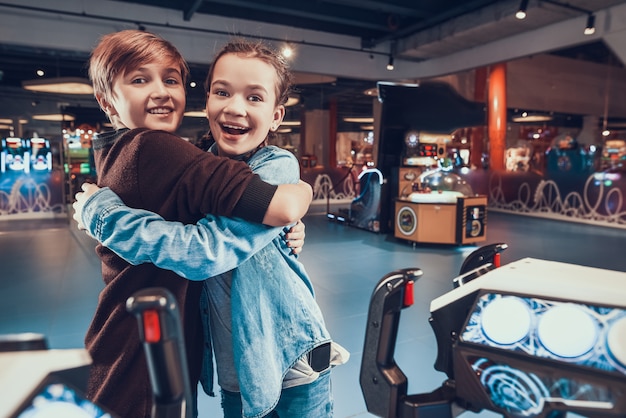 Boy and girl are piloting spacecrafts playing in arcade.