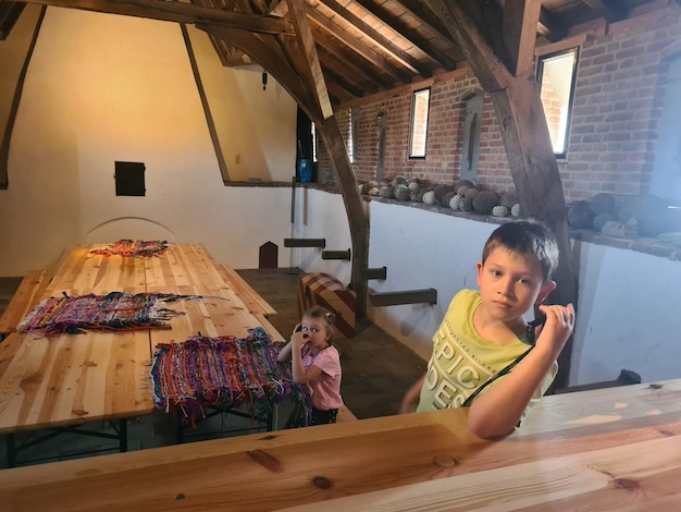 a boy and a girl are standing in front of a table with a sweater on it.