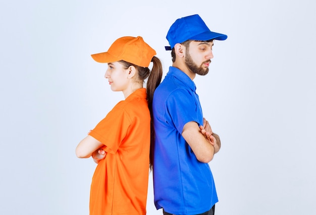 Boy and girl in blue and yellow uniforms leaning each other . 