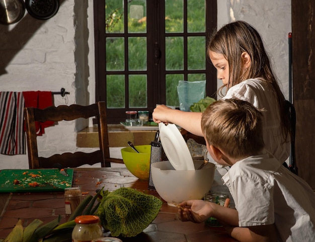 Мальчик и девочка готовят на кухне, настоящее фото