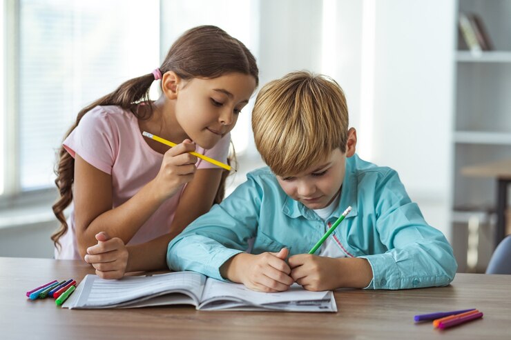 Photo the boy and a girl doing homework at the desk