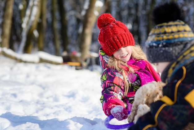 Boy and girl feed the dog