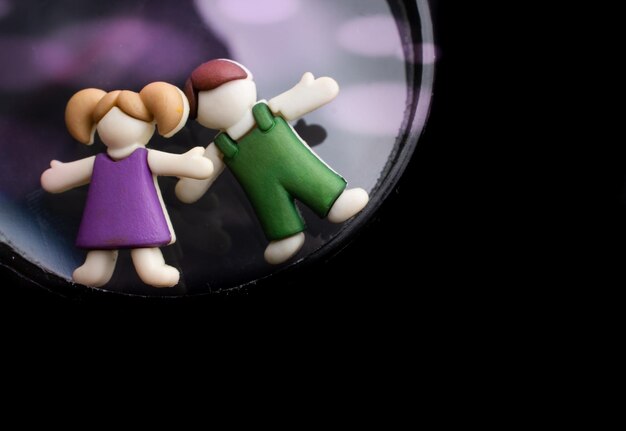 Boy and girl figurine on a magnifying glass