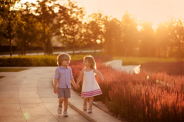 Boy and girl holding each other's hands at sunset