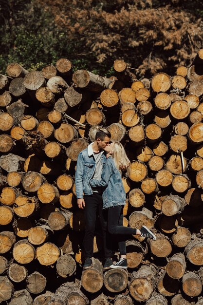 Boy and girl kissing on the stack of firewood