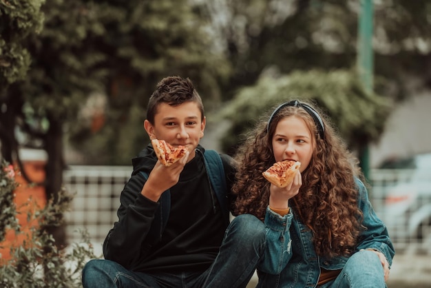 A boy and a girl on a lunch break at school A meal in front of the school during a coronavirus pandemic New normal Selective focus High quality photo