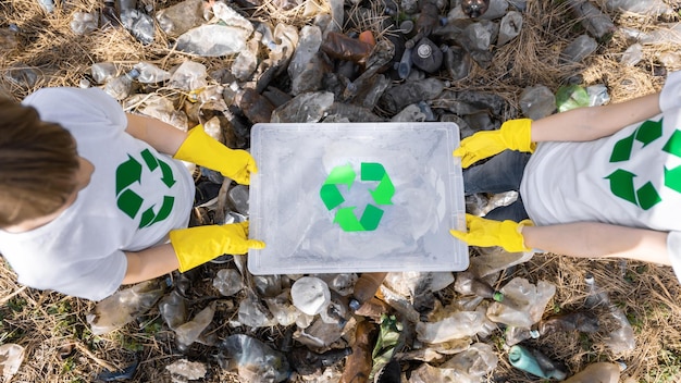 Foto ragazzo e ragazza alla raccolta dei rifiuti di plastica