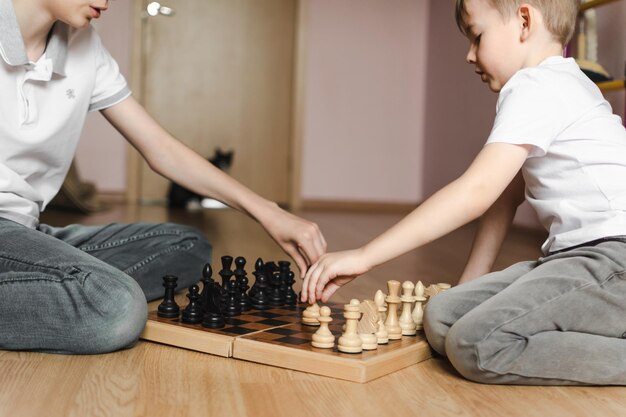 a boy and a girl playing chess on the floor