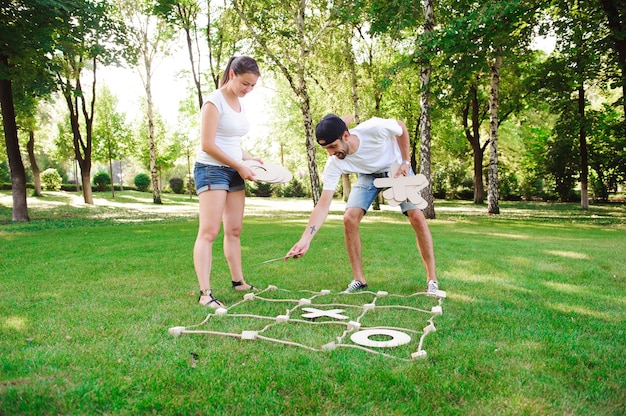 Boy and girl playing tic-tac-toe in the park.